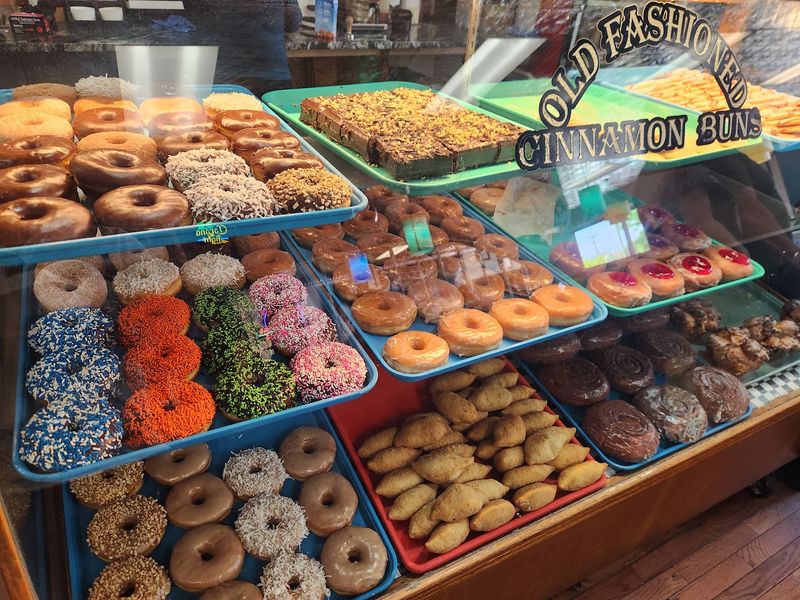 A Bakery Case of Doughnuts, Fritters, and Cinnamon Rolls