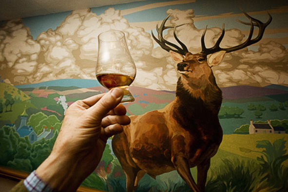 Offering a malt whisky to a red deer stag mural at the Stuart Arms, Dufftown. (Photo: Paul Tomkins)